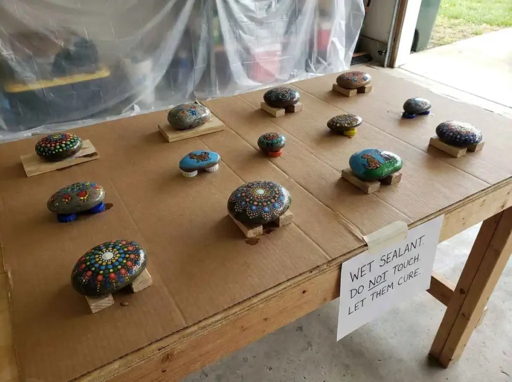 Sealed painted rocks drying on a clean protected surface