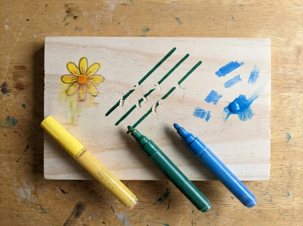 Wooden practice board showing faded colors, uneven paint pen lines, and excess paint blobs on unfinished wood.